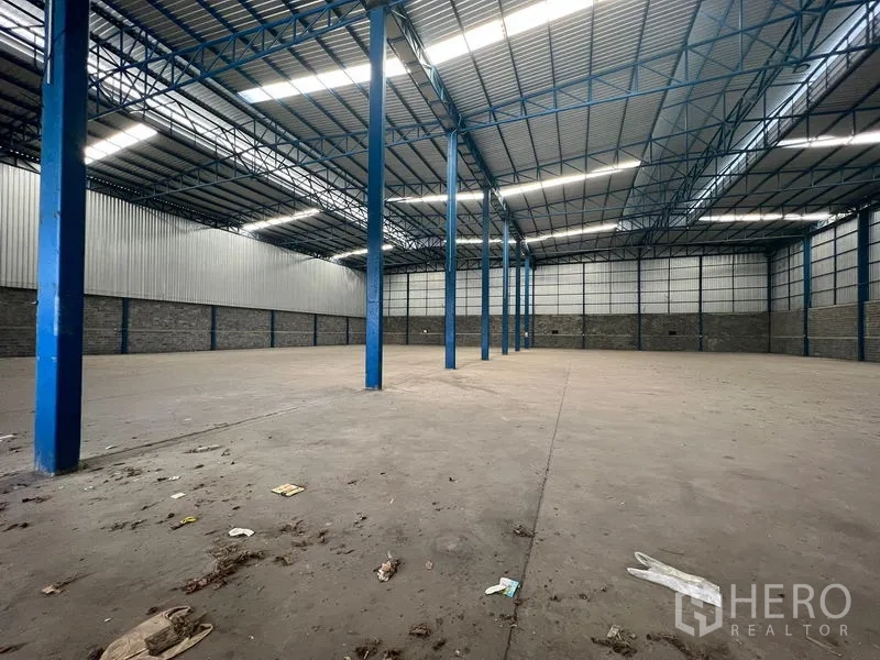Warehouse for rent in Lat Krabang, Bangkok - Clear-span storage area with concrete floor and blue steel columns throughout.