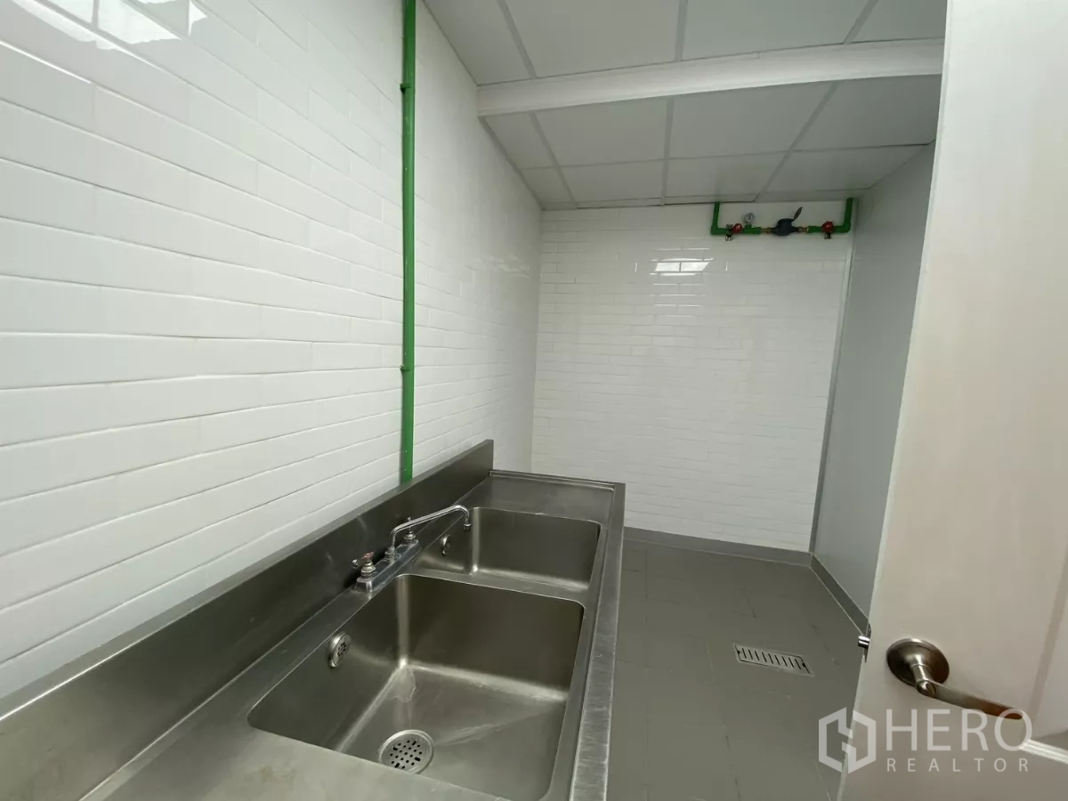 Retail Space for rent - Utility room with double stainless sink and tiled walls.