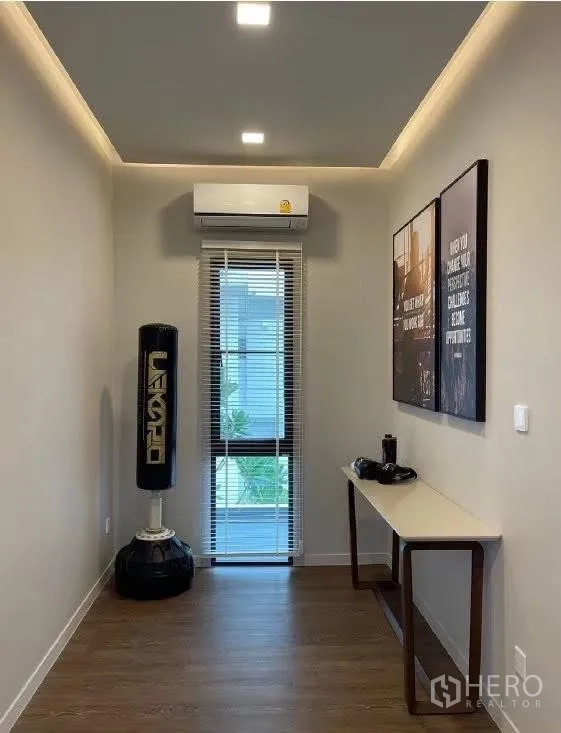 Detached House for rent in Bang Phli, Samut Prakan - Narrow multipurpose room with punching bag, desk, and window with blinds.