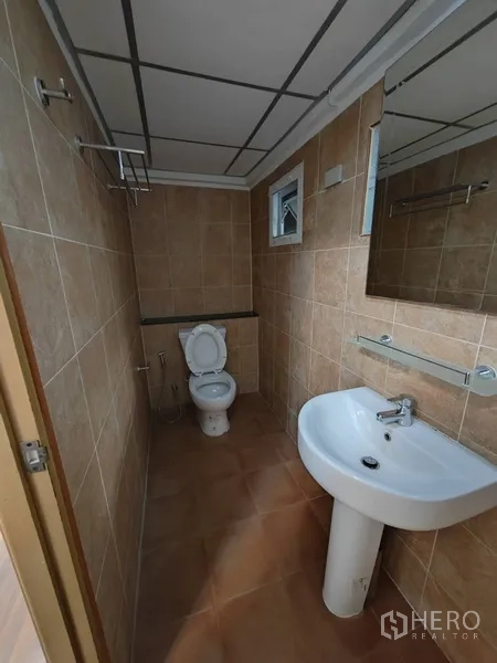 Retail Space for rent in Khlong Toei, Bangkok - Tiled bathroom with toilet, pedestal sink, mirror and small window