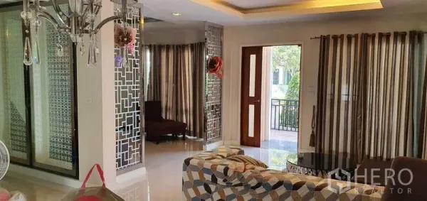 Detached House for sale in Khan Na Yao, Bangkok - Living area view with decorative mirrored screens and wooden front door opening to the terrace.