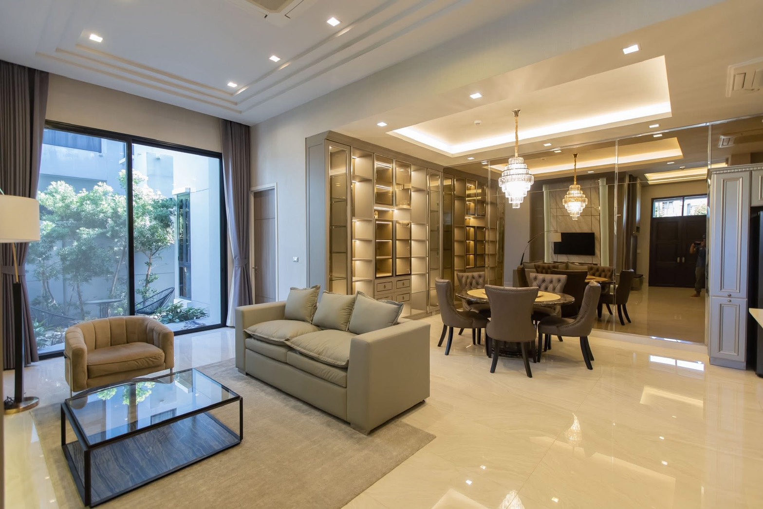 Detached House for rent in Lat Phrao, Bangkok - Spacious living-dining area with floor-to-ceiling garden window and display shelving.