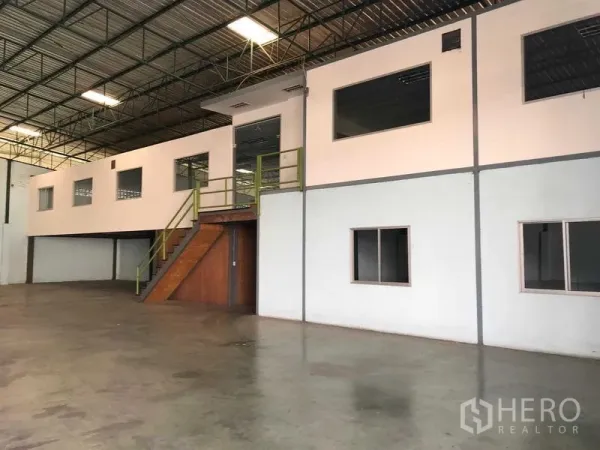 Warehouse for rent in Bang Phli, Samut Prakan - Mezzanine office block inside the warehouse with windows and a staircase overlooking the storage area.