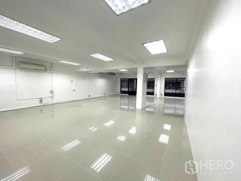 办公空间 出租在Khlong Toei, Bangkok - 明亮的开放式办公室，瓷砖地面、白墙和嵌入式灯。