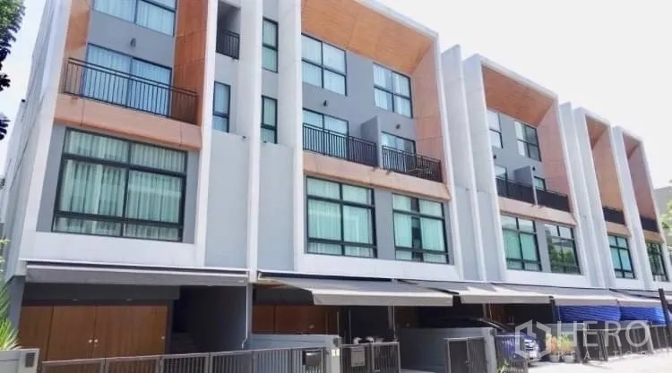Townhouse for rent or sale in Suan Luang, Bangkok - Contemporary multi-level townhouse facade with large windows and gated parking in Suan Luang.
