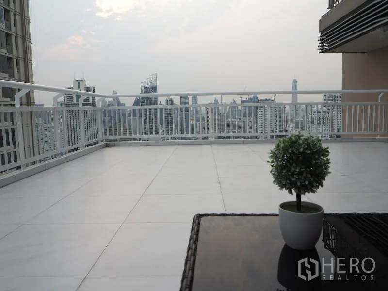 คอนโด ให้เช่าหรือขายในWatthana, Bangkok - เทอเรซกว้างชมวิวเส้นขอบฟ้าเมือง พร้อมกระถางต้นไม้บนโต๊ะ