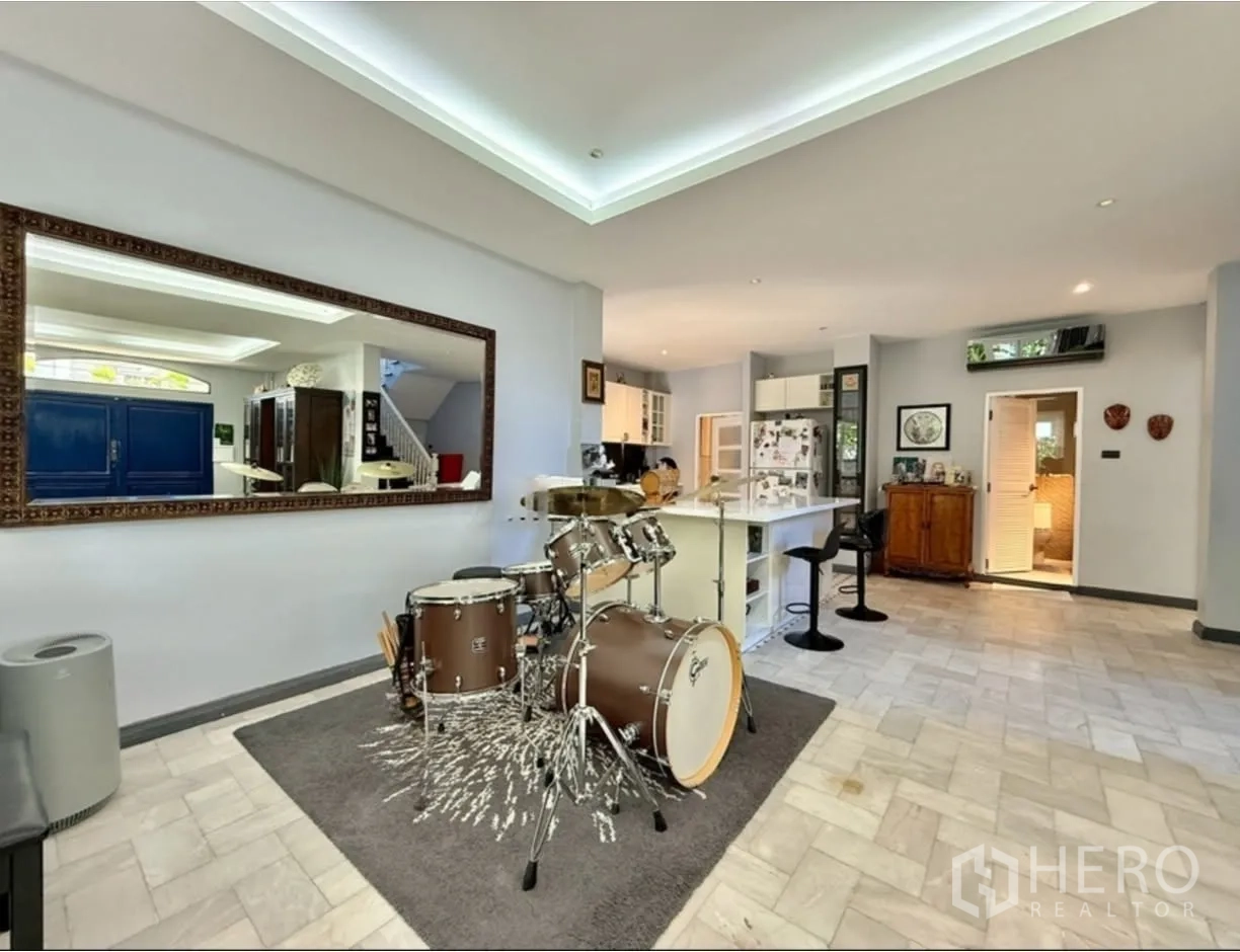 Detached House for rent in Phra Khanong, Bangkok - Open-plan kitchen and bar counter area with a drum set nearby.