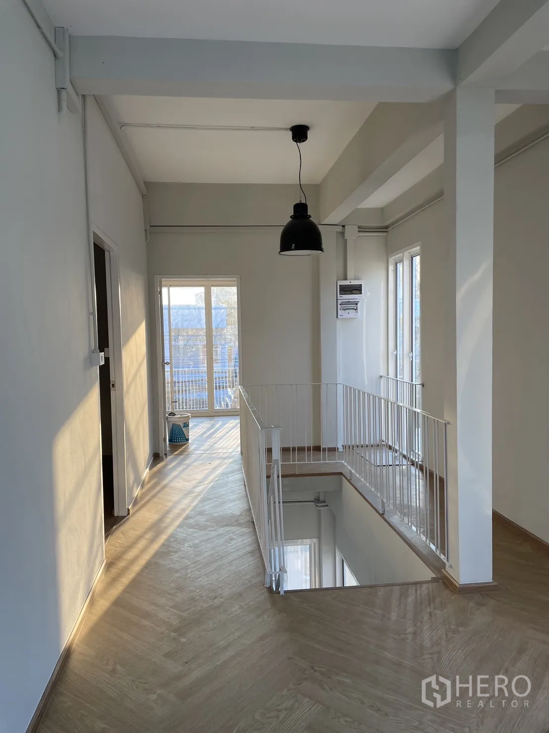 独立式住宅 出租或出售在Din Daeng, Bangkok - 二楼平台，工业风吊灯、木地板与楼梯护栏。
