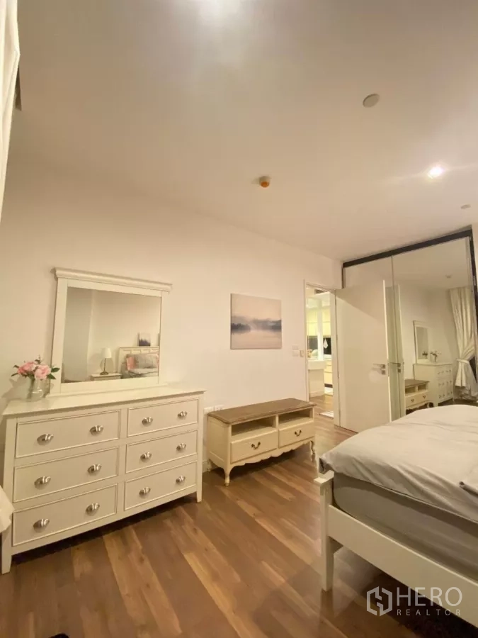Condominium for rent in Phra Khanong, Bangkok - Bedroom storage with dresser, mirror, and bench on wood floors.