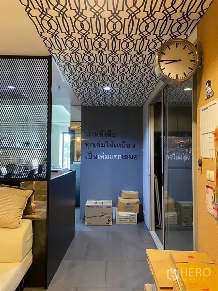 办公空间 出租在Phaya Thai, Bangkok - 走廊，镜面门、图案天花与玻璃隔断旁的时钟。