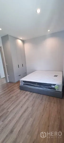 Detached House for rent in Saphan Sung, Bangkok - Bedroom with wood floors, fitted wardrobe, and new mattress set.