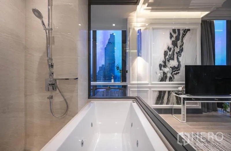 公寓 出租在Bang Rak, Bangkok - 黄昏时分的浴室视角，浴缸与玻璃望向带大理石墙的客厅