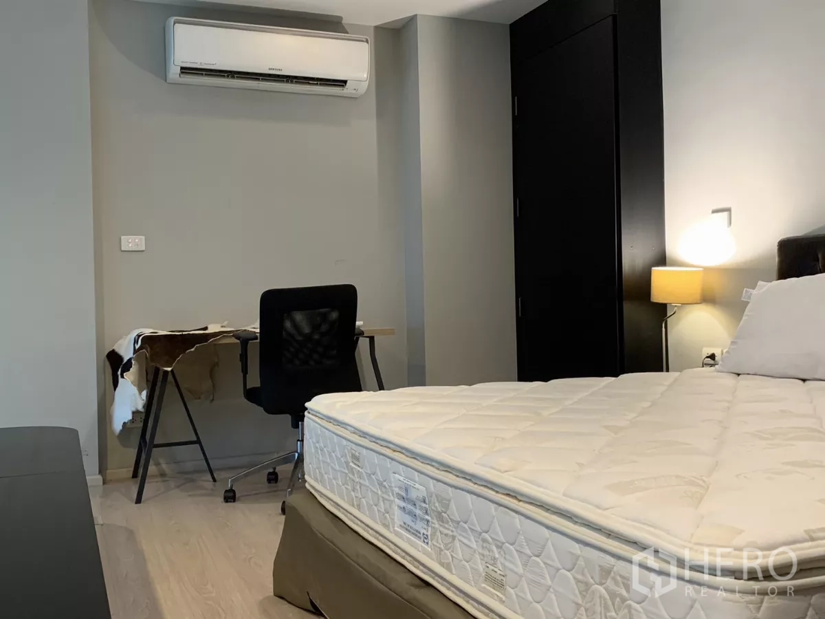 公寓 出租在Khlong Toei, Bangkok - 卧室工作区，书桌、椅子、空调与床头灯。