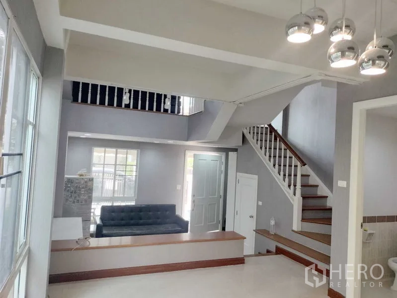 Townhouse for rent in Bueng Kum, Bangkok - Double-height entry hall featuring a staircase, pendant lights and tiled floor.