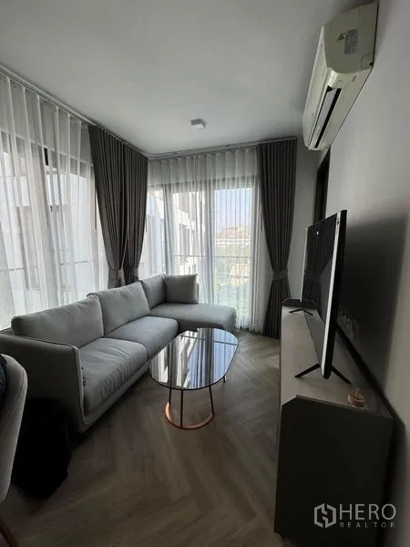 คอนโด ให้เช่าในWatthana, Bangkok - ห้องนั่งเล่นมีโซฟา ทีวี และหน้าต่างเต็มบานเปิดสู่ระเบียง