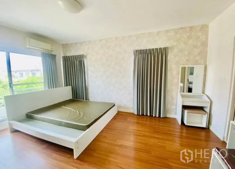 Detached House for rent or sale - Spacious master bedroom with white bedframe, balcony access, feature wallpaper and wood floors.
