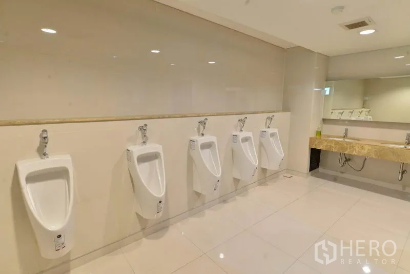 办公空间 出租在Phaya Thai, Bangkok - 明亮男卫，整排小便池与石材台面洗手区。