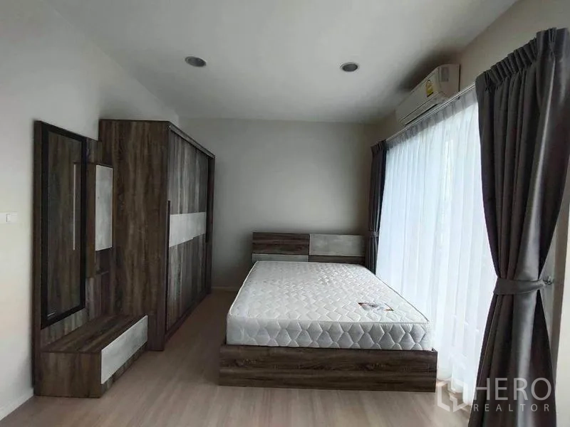 联排别墅 出租在Wang Thonglang, Bangkok - 卧室带大窗与纱帘，木质衣柜和梳妆台组合。