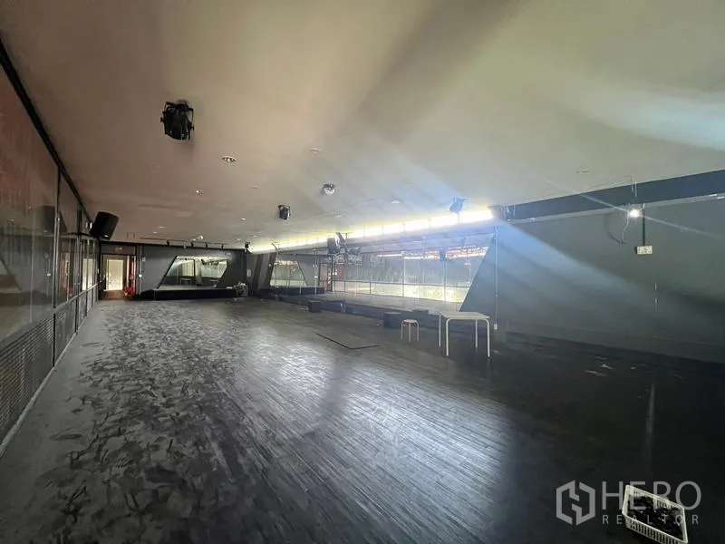 Showroom for rent in Mueang Samut Prakan, Samut Prakan - Upper mezzanine studio with wood flooring and railing overlooking main hall