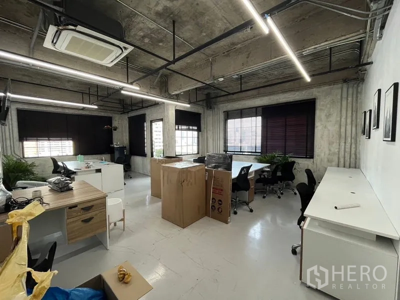 Office Space for rent in Khlong Toei, Bangkok - Spacious industrial office floor with multiple workstations, a long counter, and big windows around the room.
