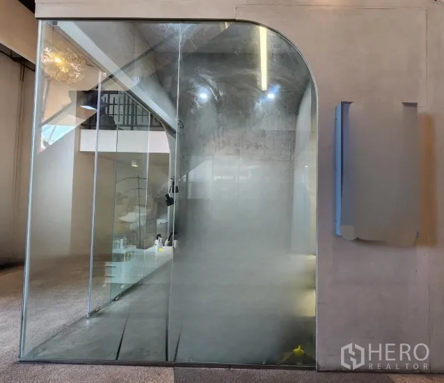 零售空间 for rent in Sathon, Bangkok - 小型零售铺，落地拱形玻璃门，清水泥灰内饰与天花射灯。