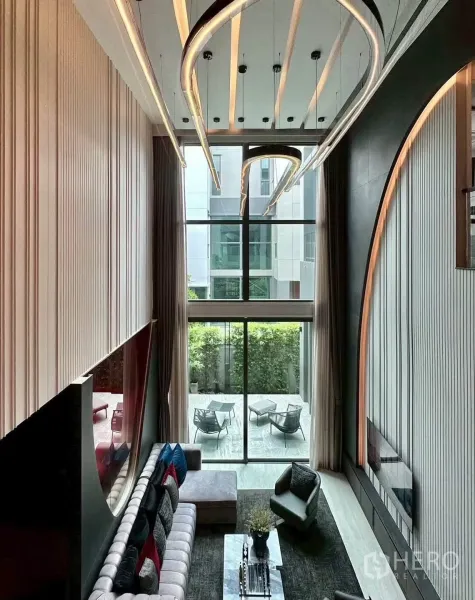独栋房屋 for rent or sale in Suan Luang, Bangkok - 从夹层俯瞰落地窗与通往绿意露台的景致。