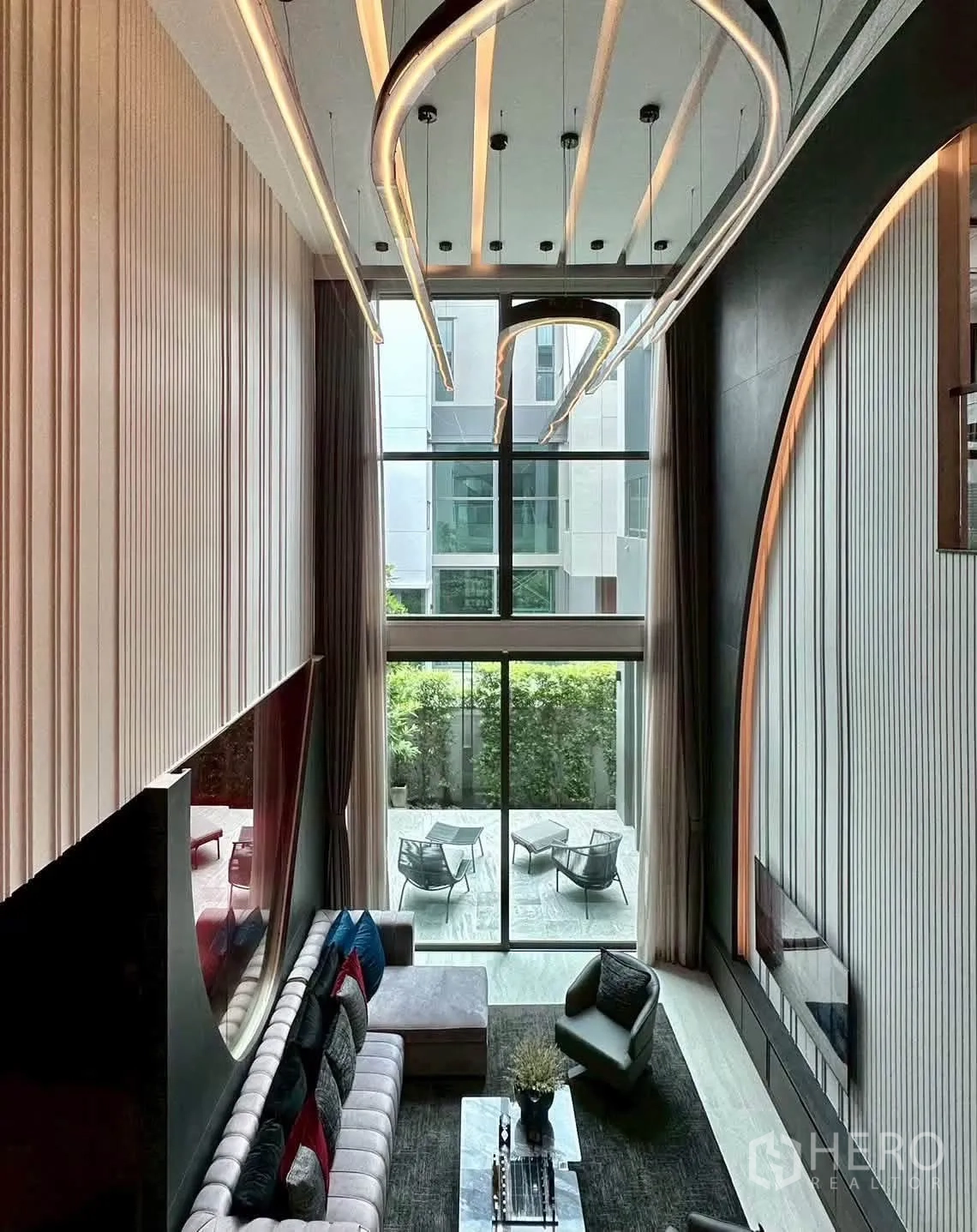 独栋房屋 for rent or sale in Suan Luang, Bangkok - 从夹层俯瞰落地窗与通往绿意露台的景致。