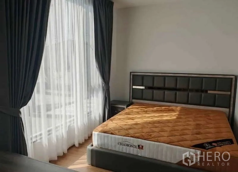 Townhouse for rent in Bang Phli, Samut Prakan - Master bedroom with large window, sheer curtains, upholstered headboard and mattress.
