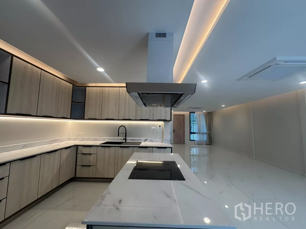 联排别墅 出租在Watthana, Bangkok - 带电磁炉与烟机的中岛，面向开放式起居区。