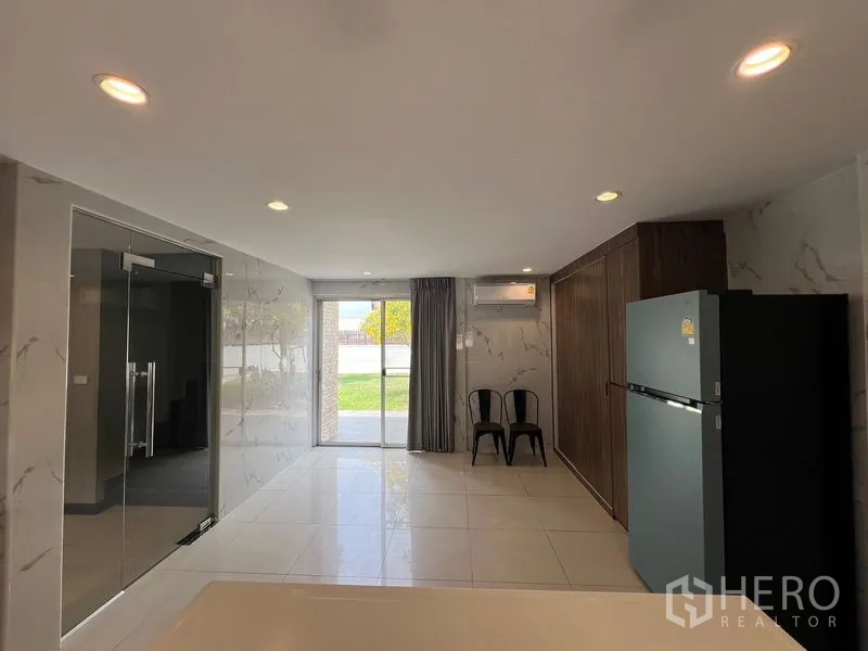 独立式住宅 出售在Mueang Pathum Thani, Pathum Thani - 厨房后段，推拉门通向花园，墙面仿石材。