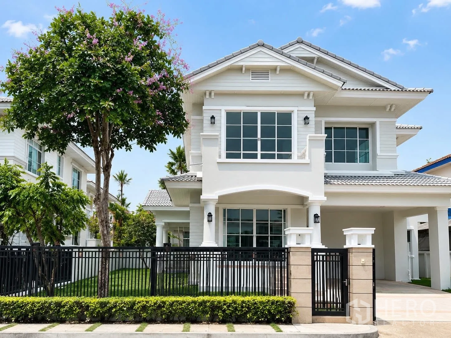 Detached House for rent in Prawet, Bangkok - White two‑storey detached house exterior with lawn, black fence, and a covered carport.