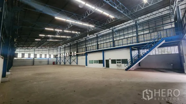 Warehouse for rent in Mueang Samut Prakan, Samut Prakan - Spacious warehouse interior with 8 m clear height, blue steel trusses and a built-in ground-floor office.