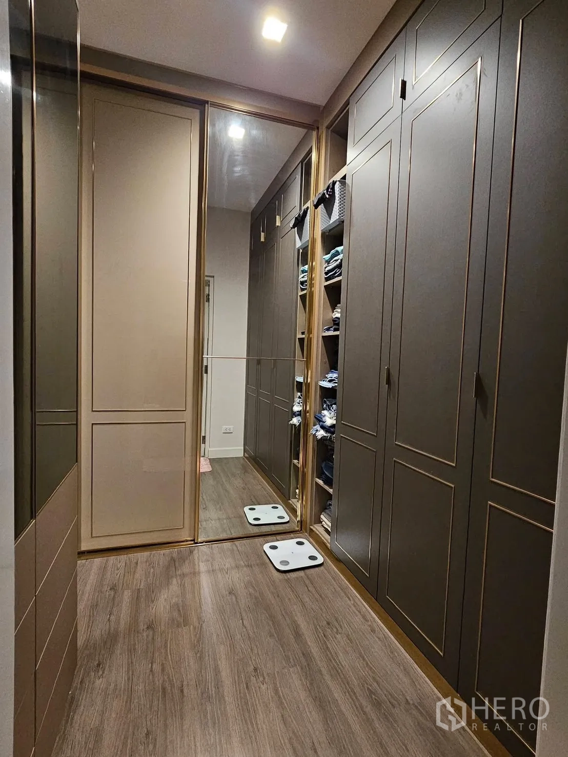 Detached House for rent in Saphan Sung, Bangkok - Walk-in wardrobe corridor with built-in cabinets and mirrored sliding door.