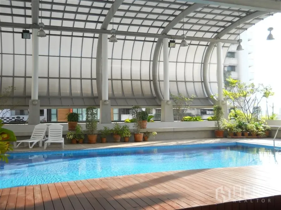 公寓 出租在Watthana, Bangkok - 带顶棚的游泳池，木质池畔平台、盆栽与躺椅