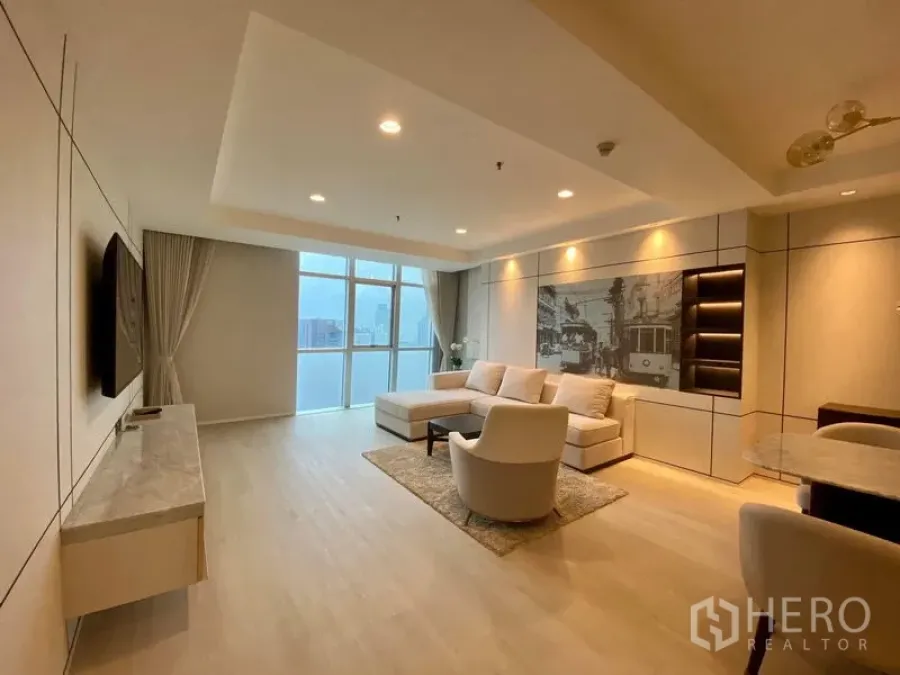 Condominium for rent in Khlong Luang, Pathum Thani - L-shaped sofa living room with TV console, feature wall and panoramic skyline view.