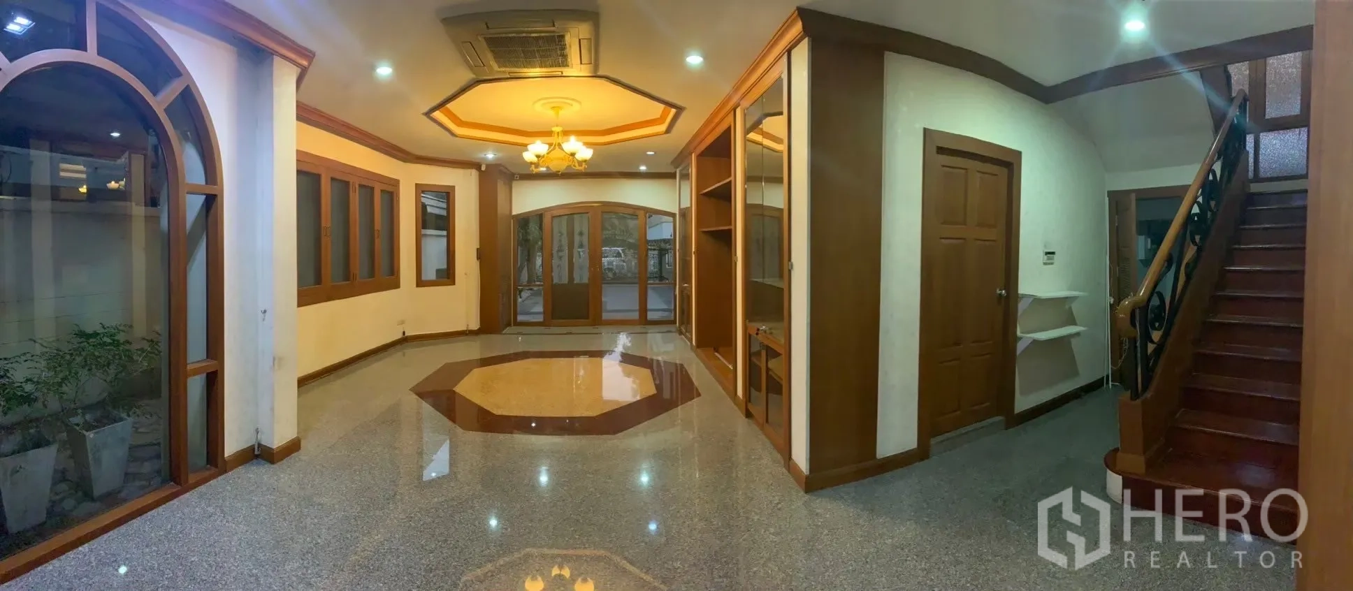 Detached House for rent in Watthana, Bangkok - Spacious open-plan living hall with glossy floor, wood trims and staircase.