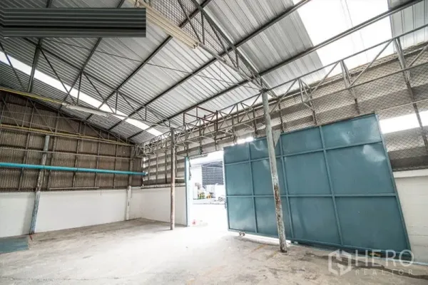 Warehouse for rent - Wide sliding steel door and loading entry at the front of the warehouse.