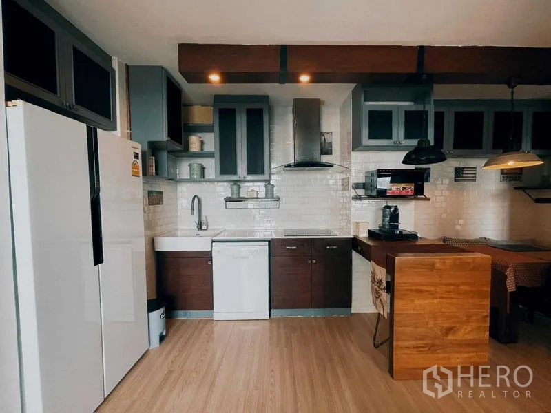 Condominium for rent in Suan Luang, Bangkok - Full kitchen with large fridge, dishwasher, and white subway tiles