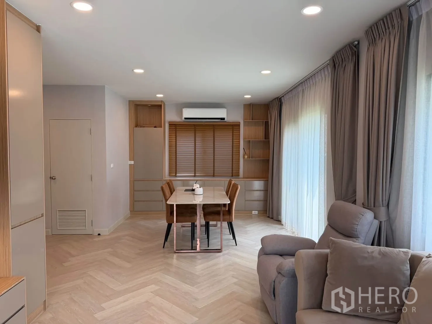 独栋房屋 for rent in Bang Phli, Samut Prakan - 开放式客餐厅，落地窗帘与木纹地面。