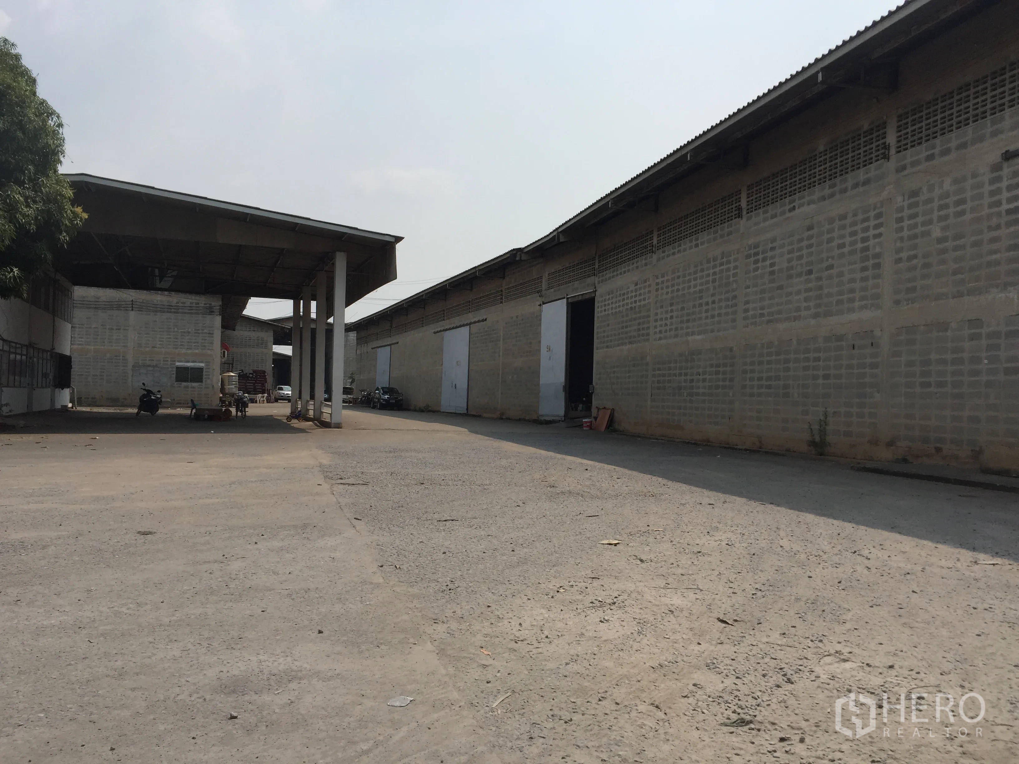 Warehouse for rent in Mueang Pathum Thani, Pathum Thani - Driveway between warehouse blocks with canopy roof, multiple loading doors and ample truck turning space.