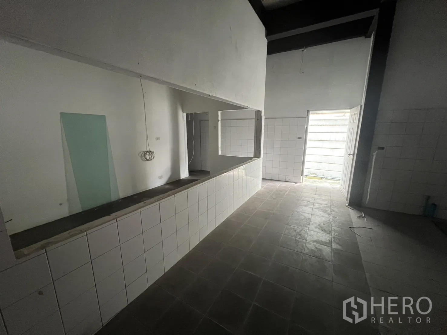 Retail Space for rent in Watthana, Bangkok - Large tiled kitchen preparation area with ducting and pipework.