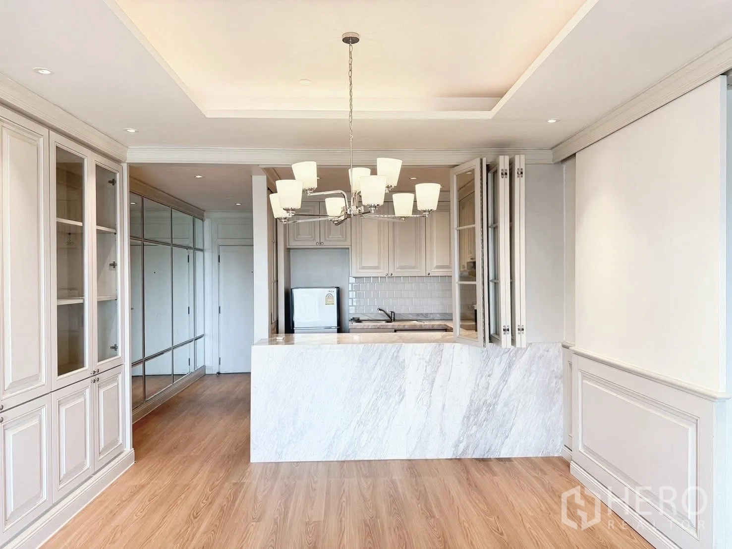 Condominium for rent or sale in Sathon, Bangkok - Large dining-living space with chandelier and display built-ins.