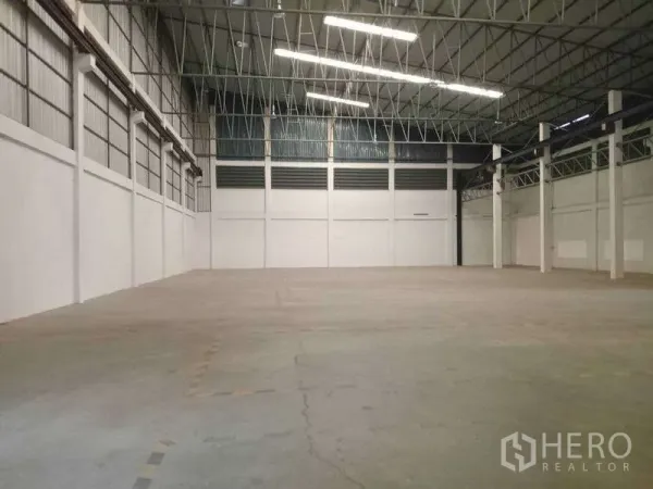 Factory for rent in Mueang Samut Prakan, Samut Prakan - Large open manufacturing space with concrete floor, bright strip lighting and column grid.