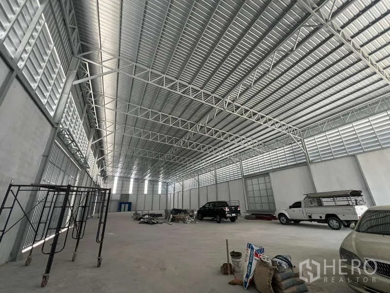 货栈 出租在Prawet, Bangkok - 高净空仓库，钢结构屋顶与百叶通风板，开放储存区。