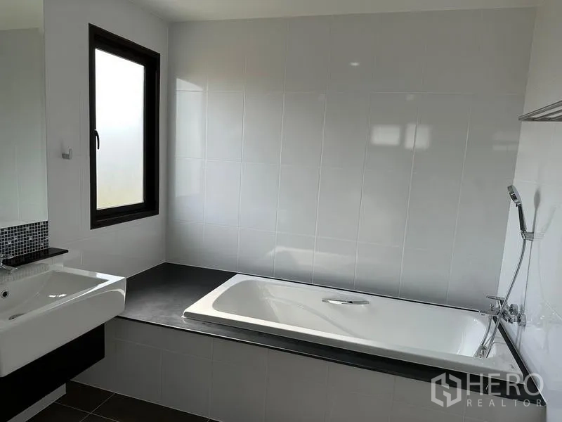 Detached House for sale in Saphan Sung, Bangkok - Bathroom with built-in bathtub, handheld shower and window.