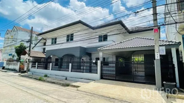 独立式住宅 出租在Bang Kapi, Bangkok - 双层独立屋外观，带围栏与带顶车库，位于安静街道。