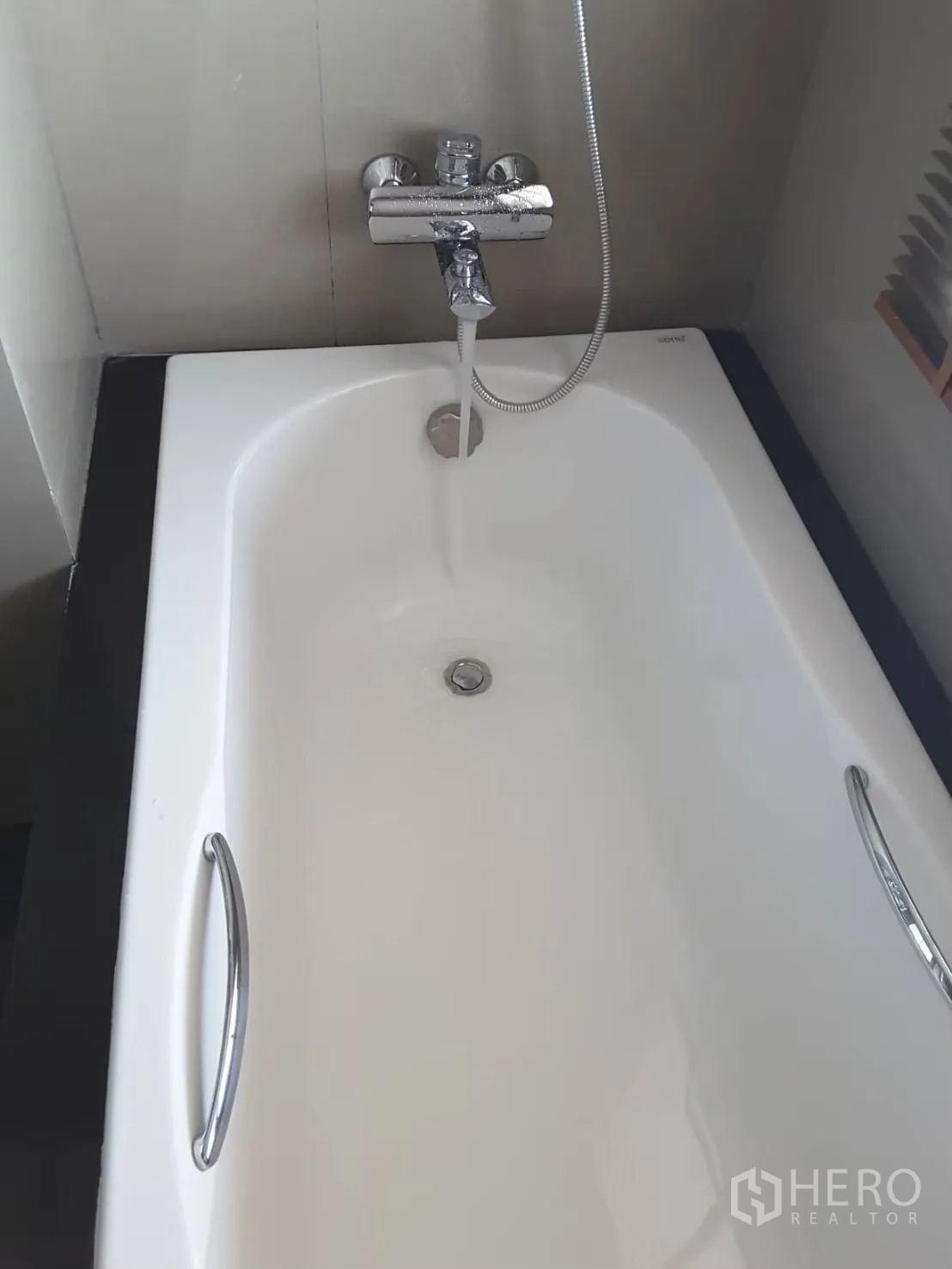 Condominium for rent in Khlong Toei, Bangkok - Close-up of a white bathtub with chrome faucet and hand shower.