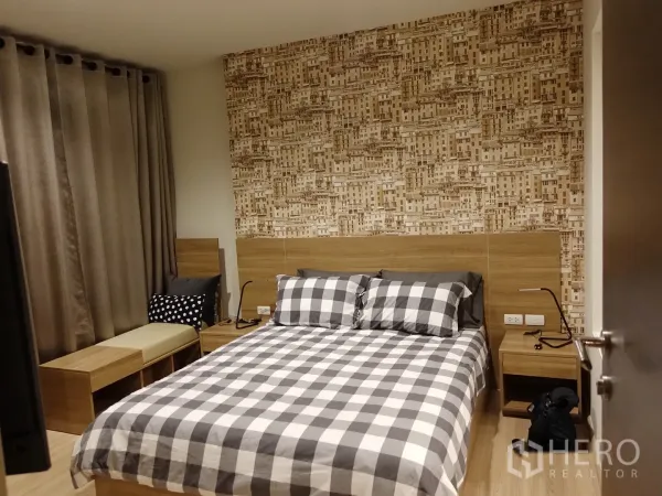 Condominium for rent in Sathon, Bangkok - Well-lit bedroom with blackout curtains, twin bedside tables, lamps and geometric feature wallpaper.