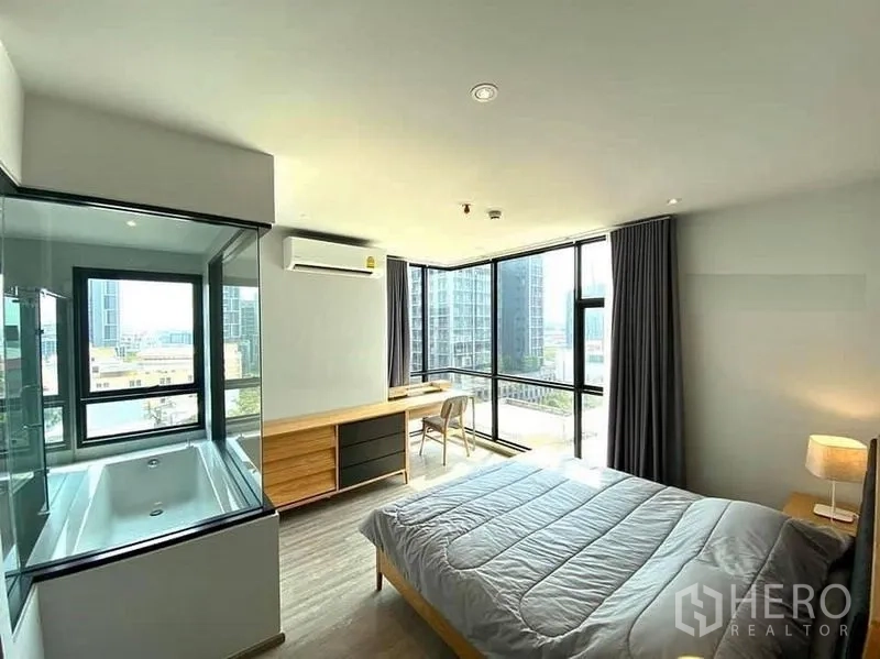 公寓 出租在Watthana, Bangkok - 转角主卧享全景城市景观，玻璃隔断后设浴缸。