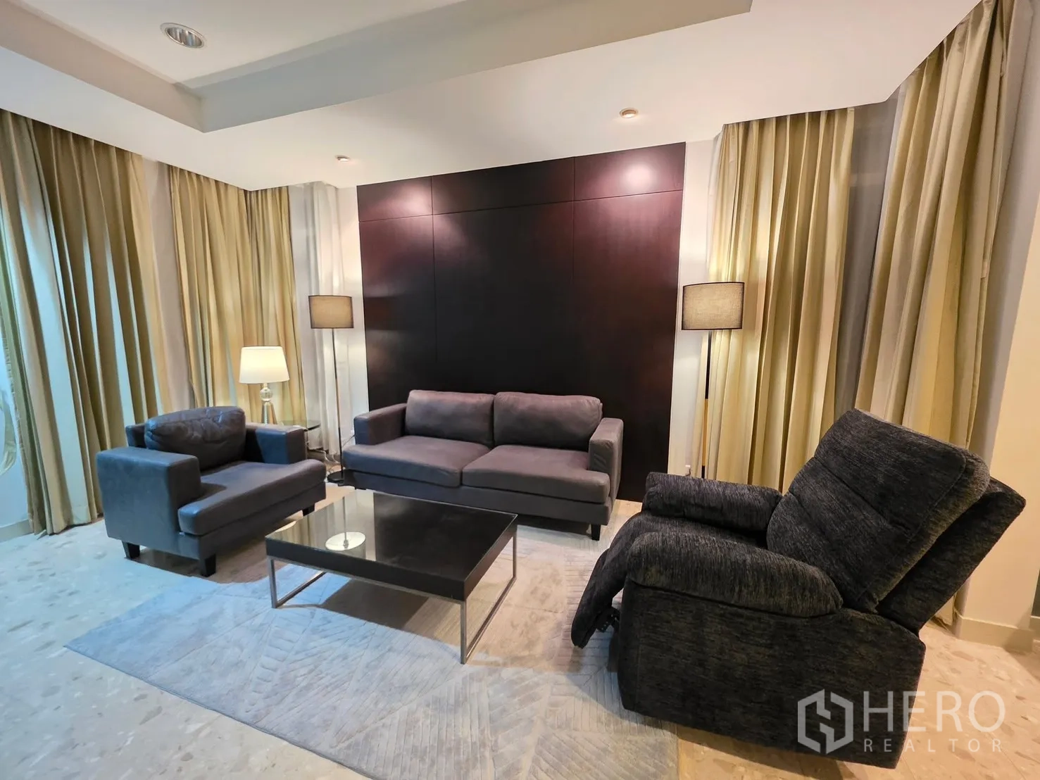 Detached House for rent in Wang Thonglang, Bangkok - Living room with sofa set, recliner, coffee table, floor lamps, and full-height curtains.